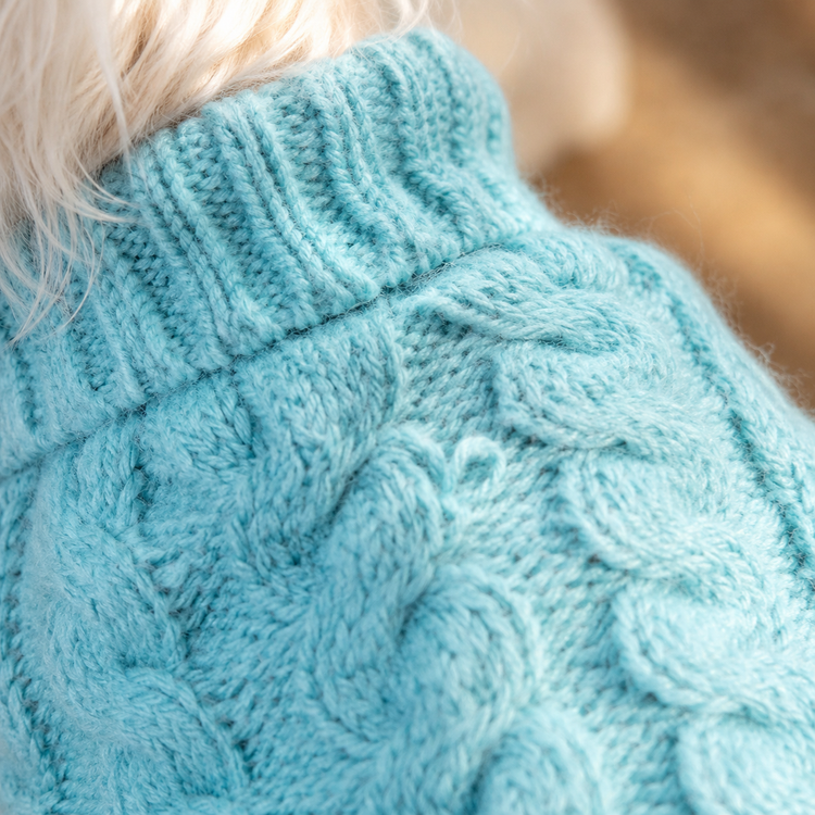 Close-up of the sky blue cable knit texture and ribbed turtleneck
